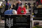 　３月３１日、ウクライナ・ブチャでロシア占領下に犠牲となった人々を追悼する式典が開かれ、戦死したウクライナ兵の墓に花を供える親族（ＡＰ＝共同）