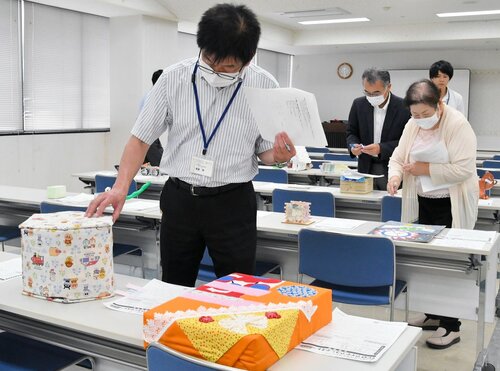 寄せられた力作を一つずつチェックする審査員ら＝１４日、鳥取市富安２丁目の新日本海新聞社