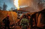 　砲撃で破壊された住宅周辺で消火活動に当たる救助隊員＝７日、ウクライナ東部ドネツク（ロイター＝共同）