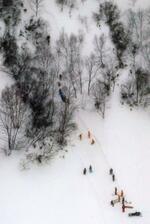 　２０１７年３月、登山講習中の高校生らが雪崩に巻き込まれたスキー場周辺で救助活動をする消防隊員ら＝栃木県那須町