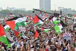 　５日、ジャカルタの独立記念塔周辺で開かれた集会で、パレスチナの旗を掲げる人々（共同）