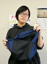 　高松刑務所と連携して開発したエコバッグと木製のしおりを手にする香川大の吉本清乃さん＝２０２４年３月、高松市