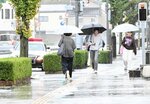 大雨の中、傘を差して歩く通行人＝２日、鳥取市東品治町