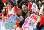 　アジアパラ大会の開幕を控えた中国・杭州市で、聖火ランナーに声援を送る人たち＝２１日（共同）