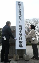 正門前に大きな看板を設置する職員ら＝１２日、鳥取市湖山町南４丁目の鳥取大