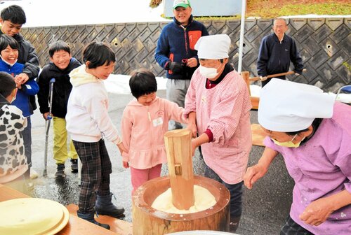 杵と臼を使った昔ながらの餅つきを体験する参加者＝２１日、香美町小代区実山の地域連携センター