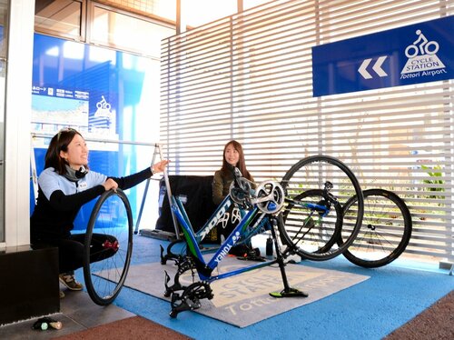 新設されたサイクルステーションで自転車を組み立てるおおやさん（左）とあむちゃん！さん＝１９日、鳥取市湖山町西４丁目の鳥取砂丘コナン空港