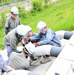 排水ポンプの操作方法を確認する参加者ら＝６日、倉吉市福守町の天神川河川防災ステーション
