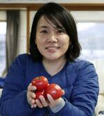 　高知県日高村特産のトマトを手にする小野加央里さん
