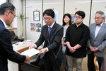 足羽教育長（左）に申し入れ書を手渡す岡田委員長ら＝２８日、鳥取県庁
