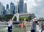 　シンガポールのマーライオン像の前で写真撮影する中国人観光客ら＝２０２４年３月（共同）