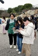 　「皇居を巡る謎解きの旅」のオープニングイベントに参加した人たち。手前左は伊沢拓司さん＝１７日午後、皇居・東御苑