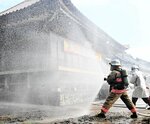 関係機関と連携しながら放水訓練を行う消防隊員ら＝２０日、香美町香住区下浜の帝釈寺