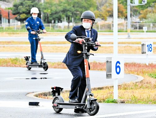 電動キックボードに試乗し、安全な走行方法を確認する警察官ら