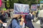 パンデミック条約に反対する集会のデモで、プラカードを掲げる参加者＝５月３１日、東京都内