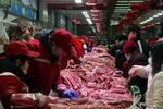 　客対応をする北京の市場の豚肉販売員ら＝２日（ロイター＝共同）