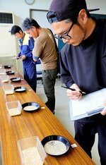 今年収穫したプリンセスかおりの玄米を評価する生産者ら＝２５日、鳥取市橋本の県農業試験場