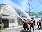 火が燃え広がった民家の消火活動にあたる消防団員ら＝２９日、香美町香住区沖浦