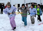 「パシュート・ストラックアウト」種目で、連なって雪上を走る参加者＝１日、新温泉町桐岡の照来小グラウンド