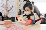 ティッシュ箱作りに取り組む男の子＝２０日、境港市上道町の市民交流センター