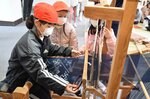 弓浜絣の織り作業を体験する児童＝１６日、米子市中町の山陰歴史館