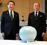 平井知事（左）に「青瓷輪花壺」を贈呈した坂本さん＝１３日、鳥取県庁