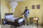 　移民らの宿泊施設「ホープ・ホステル」の部屋を案内するバキナ・イスマイルさん＝１月１６日、ルワンダの首都キガリ（中野智明氏撮影・共同）