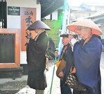 旅館や民家を巡り、手を合わせてお経を唱える僧侶ら＝１２日、三朝町の三朝温泉街