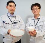 　廃棄される卵の殻を使った高級食器「ボーンチャイナ」を手にする鳴海製陶研究開発部の西部徹部長（左）ら＝５月、名古屋市