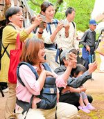 わが子の雄姿をスマートフォンで撮影しながら声援を送る保護者たち＝１２日、新温泉町の浜坂相撲場