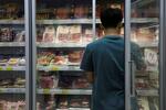 　北京のスーパーに並ぶ豚肉などの肉製品と従業員＝１３日（ロイター＝共同）