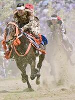 　「相馬野馬追」の甲冑競馬で、土ぼこりを上げて疾走する騎馬武者＝２６日午後、福島県南相馬市