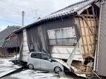 　倒壊した住宅と下敷きになった車＝１月２７日、石川県輪島市