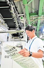 刷り上がった選挙公報を確認する県選管職員＝１７日、鳥取市五反田町の日本海新聞製作センター