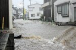 水があふれ川のようになった吉岡温泉街＝１３日午前７時２０分、鳥取市吉岡温泉町（日本海新聞湖南専売所提供）