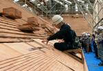 　参詣者に公開されたこけらぶき屋根のふき替え作業＝８日午前、鳥取県大山町