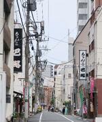 　「ちゃんこ」と書かれた飲食店の看板がのぞく脇道＝東京都墨田区