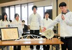 構造デザイン部門で７連覇を果たした橋模型「要」の構造を説明する学生＝昨年１２月２０日、米子市役所