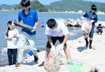 消波ブロックの隙間にあるごみを拾い集める生徒たち＝２９日、香美町香住区下浜の香住海岸