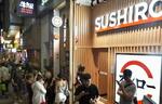 　日系大手回転ずしチェーン店の前に行列する人たち＝８月３０日、香港（共同）