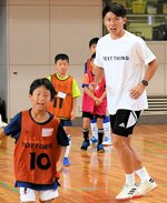 子どもたちと一緒に体を動かしてプレーの助言を行う太田さん（右）＝３０日、米子市東福原８丁目の米子産業体育館