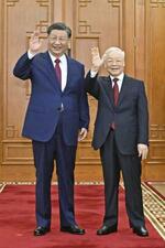 　笑顔で手を振るベトナム最高指導者グエン・フー・チョン共産党書記長（右）と中国の習近平国家主席＝２０２３年１２月、ハノイ（新華社＝共同）