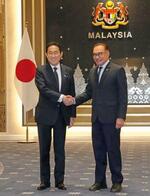 　会談前に握手するマレーシアのアンワル首相（右）と岸田首相＝５日、クアラルンプール（共同）