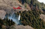 　岩手県大船渡市の山林火災現場で散水するヘリコプター＝２３日午後２時３８分