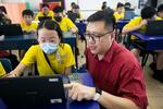 　レークサイド小学校でデジタル技術を活用したカリキュラムを考案するチャン・コクホンＩＴ部門長（右）＝２０２３年１１月、シンガポール（共同）