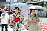 　日傘を差して歩く人たち＝２５日午後、東京・浅草