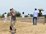 暑さの中タオルや日傘を使いながら砂丘を歩く観光客ら＝３日、鳥取市の鳥取砂丘