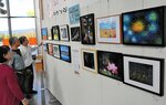 展示作品をチェックする米子写交会の会員たち＝２３日、境港市の米子鬼太郎空港