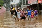 　中国河北省で冠水した道を歩いて避難する住民ら＝３日（共同）