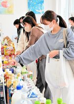 フードドライブで集まった食品を手に取る学生たち＝１５日、倉吉市の鳥取看護大・鳥取短期大